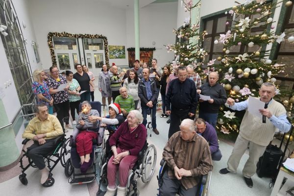 Wspólne kolędowanie na holu mieszkańców i pracowników.
