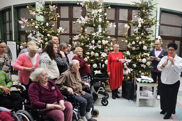 Panie Dyrektor składa życzenia mieszkańcom zgromadzonym na holu.