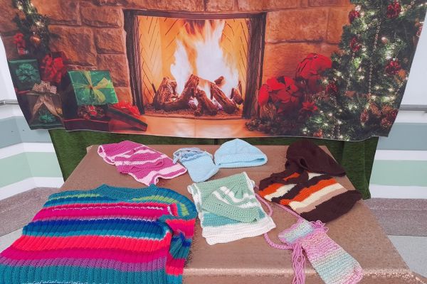 Czapki i szaliki na stole.