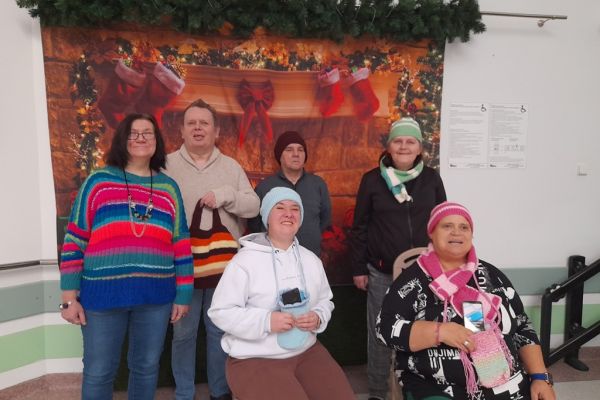 Mieszkańcy prezentują ubrane czapki i szaliki.