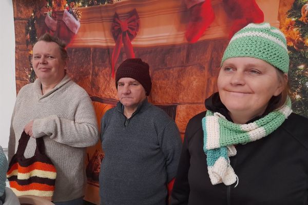 Mieszkańcy prezentują ubrane czapki i szaliki