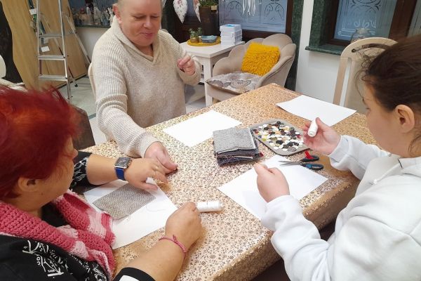 Mieszkańcy przyszywaja guziki.