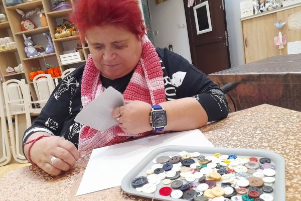 Mieszkanka przyszywa guziki.