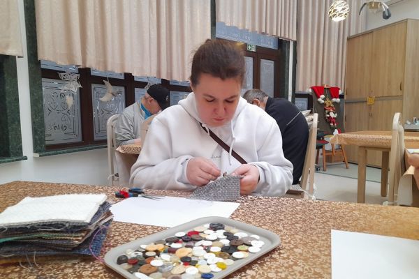 Mieszkanka przyszywa guziki.