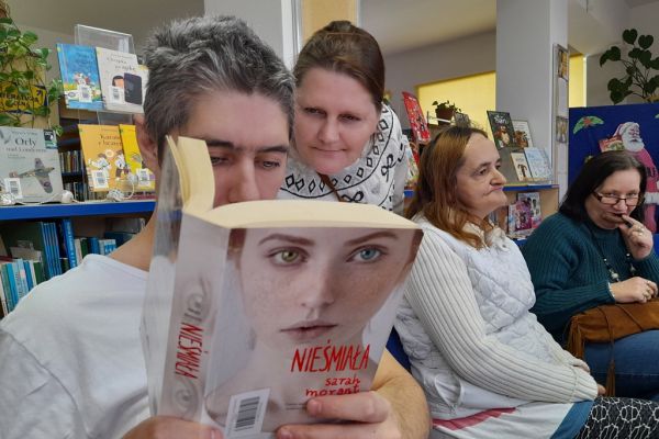 Mieszkańcy siedzą w bibliotece.