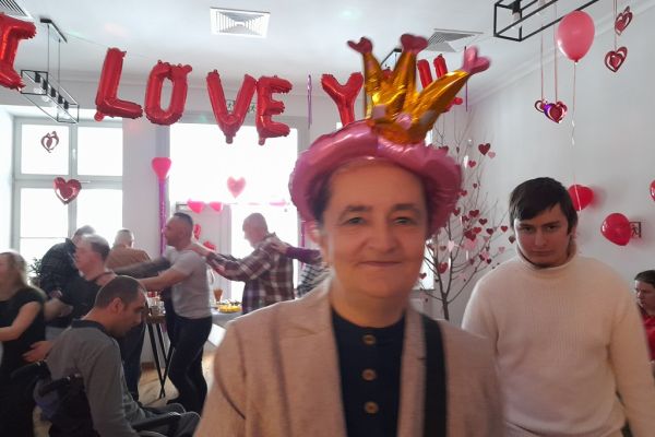 Mieszkanka z koroną pośród innych tańczących na balu.