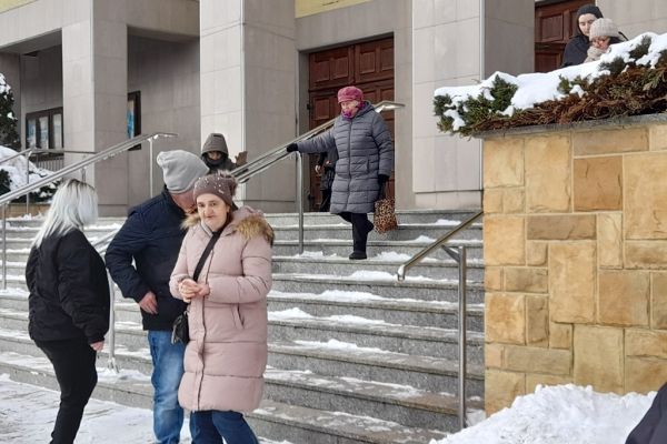 Mieszkańcy schodzą schodami przed kościołem.