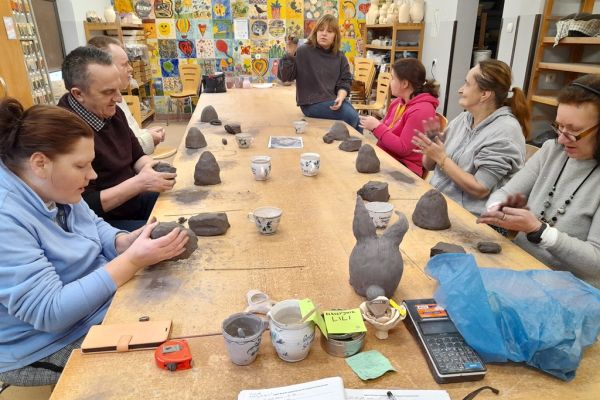Mieszkańcy w pracowni lepią w glinie.