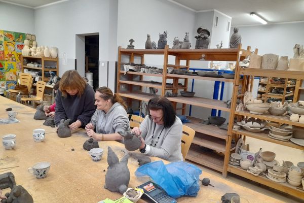 Mieszkańcy w pracowni lepią w glinie.