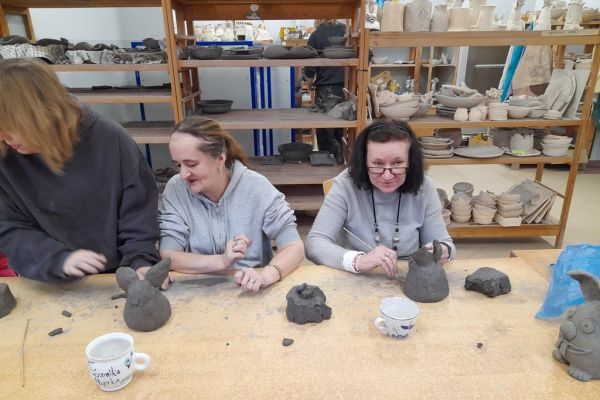 Mieszkańcy w pracowni lepią w glinie.