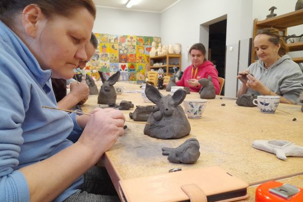 Mieszkańcy w pracowni lepią w glinie.