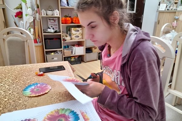 Mieszkanka wycina kwiaty z papieru.