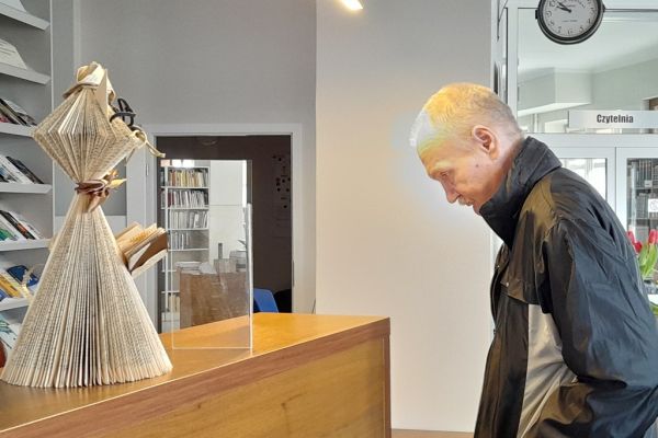 Mieszkaniec stoi w czytelni.