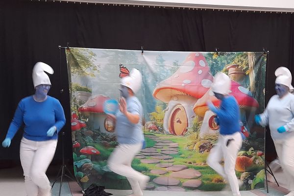 Występujacy aktorzy w strojach smerfów.