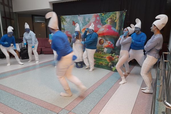 Występujacy aktorzy w strojach smerfów.