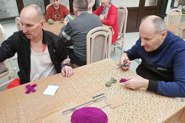 Mieszkańcy wykonują kwiaty z włóczki.