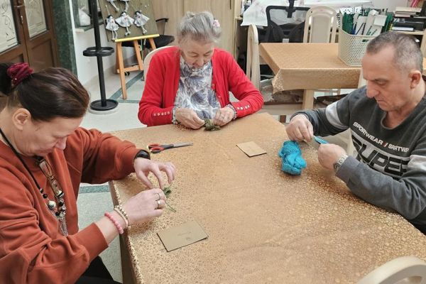 Mieszkańcy wykonują kwiaty z włóczki.