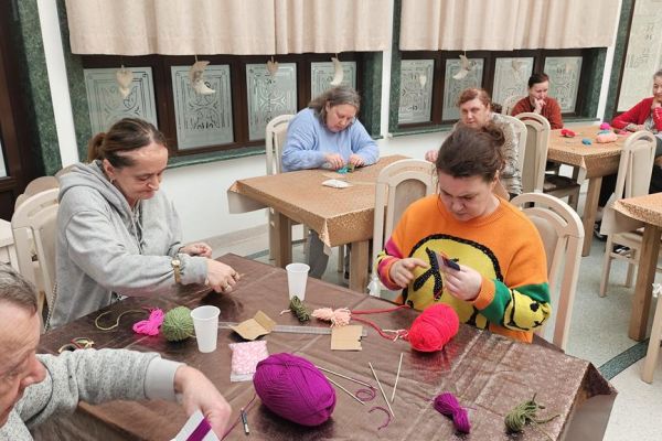 Mieszkańcy wykonują kwiaty z włóczki.