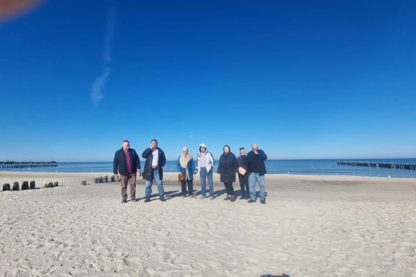 Mieszkańcy stoją na plaży.