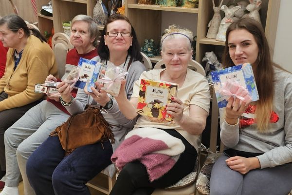 Obdarowane kobiety siedzące na krzesełkach.