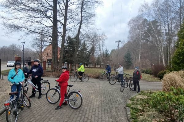 Mieszkańcy odpoczywaja stojąc przy swoich rowerach.
