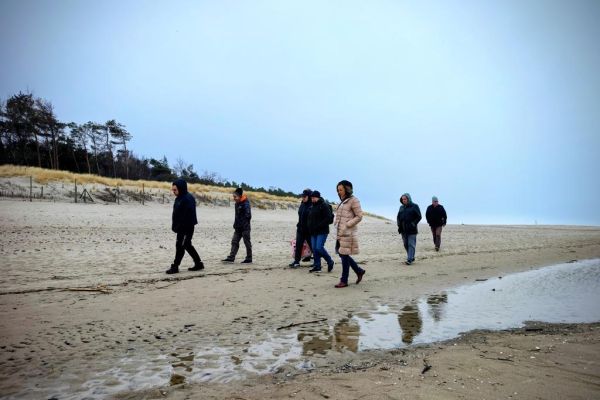 Mieszkańcy spaceruja po plaży.