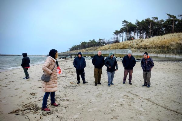 Mieszkańcy spaceruja po plaży.