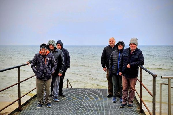 Mieszkańcy stoją na schodach przy plaży.