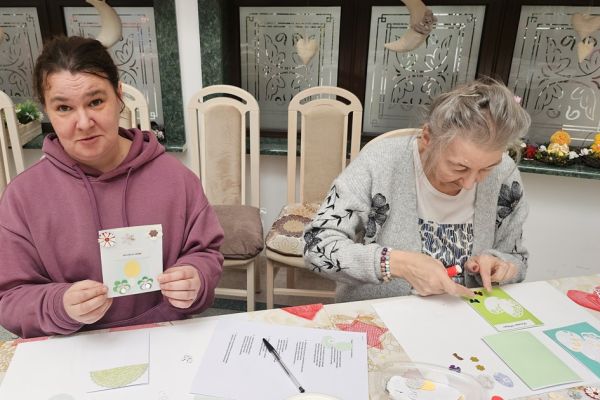 Mieszkańcy dekorują kartki świąteczne.
