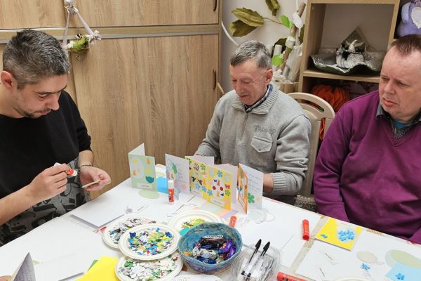 Mieszkańcy dekorują kartki świąteczne.