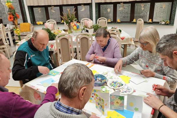 Mieszkańcy dekorują kartki świąteczne.