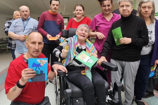 Mieszkańcy trzymaja kartki z życzeniami od dzieci.