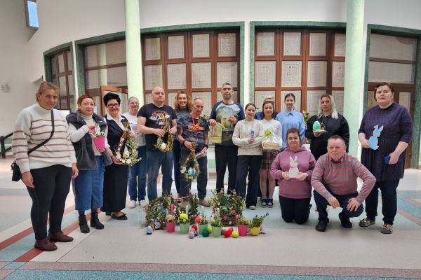 Pani Dyrektor i mieszkańcy i przedstawiciele szkoły stoją na holu z przywiezionymi dekoracjami.