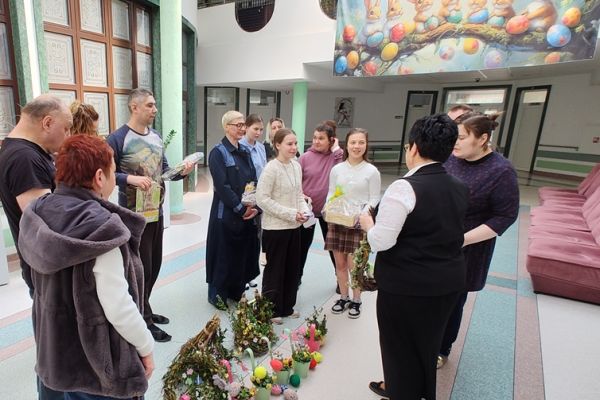 Pani Dyrektor i mieszkańcy i przedstawiciele szkoły stoją na holu z przywiezionymi dekoracjami.