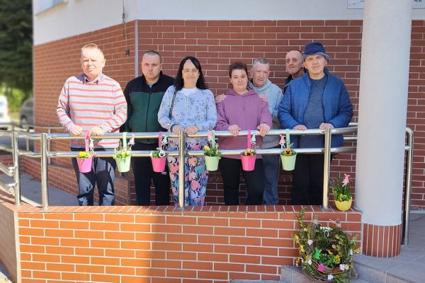 Mieszkańcy stojący przy dekoracjach w doniczkach.