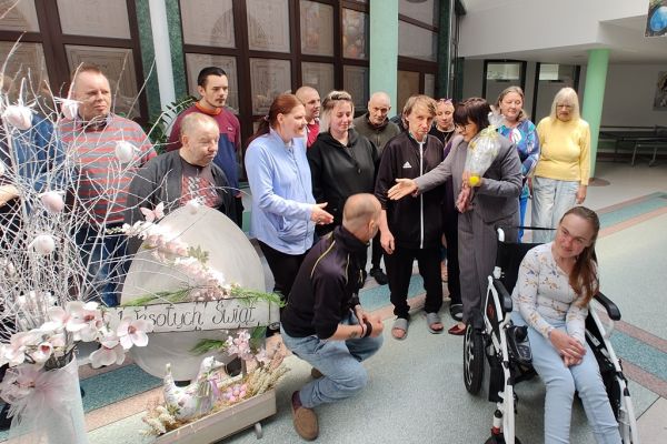 Mieszkańcy stoją na holu domu podczas kiedy Pani Wójt składa im życzenia.