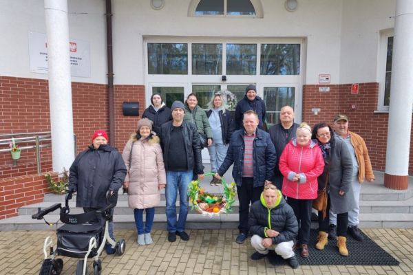 Mieszkańcy przed wejściem do domu ze święconką.