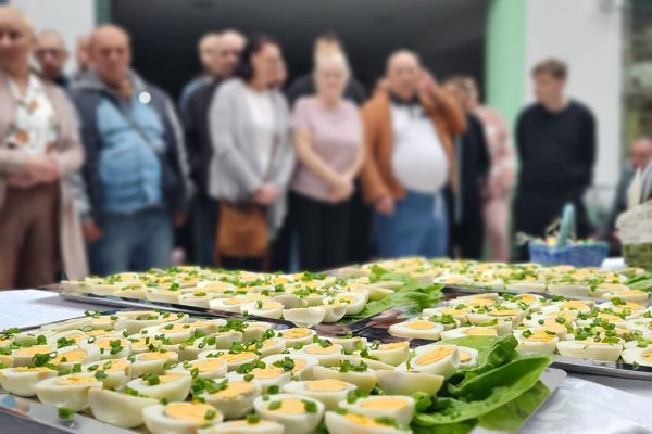  Stół z tacami pokrojopnych jajeka w tle stojącyb mieszkańcy.