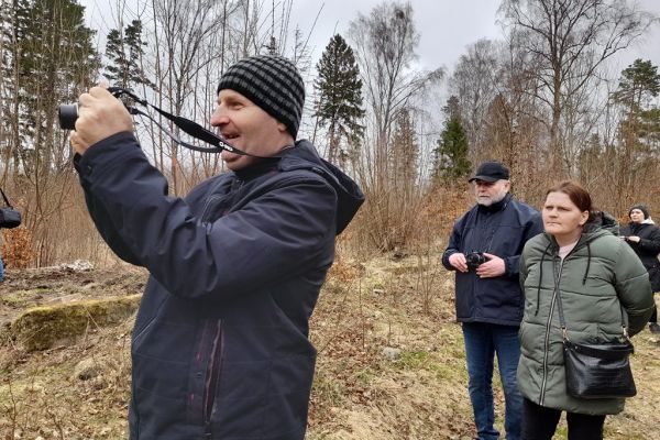 Mieszkańcy trzymają aparaty i fotografują przyrodę.