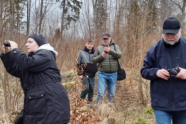 Mieszkańcy trzymają aparaty i fotografują przyrodę.