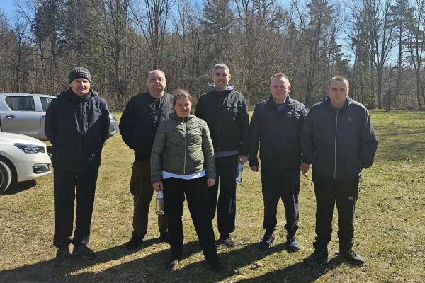 Zdjęcie grupowe mieszkańców w lesie.