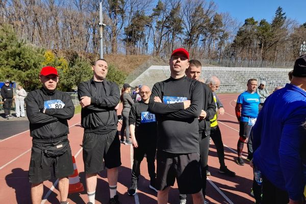 Mieszkańcy ustawieni do startu w biegach na stadionie wraz z innymi uczestnikami.