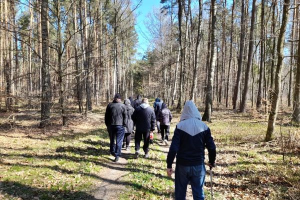 Mieszkańcy idą lasem.