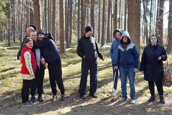 Mieszkańcy stoją w lesie.