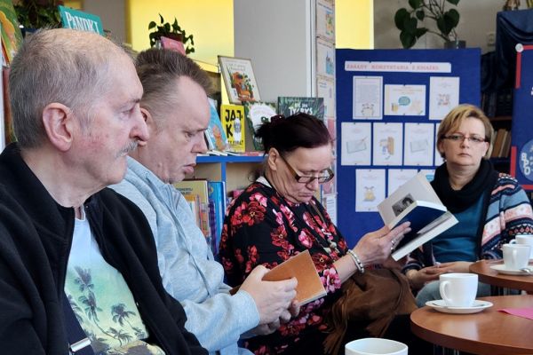 Mieszkańcy siedzą i czytają książkę.