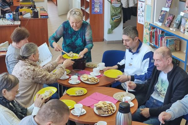 Mieszkańcy spożywaja poczęstunek.