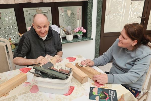 Dwoje mieszkańców szlifuje drewno.