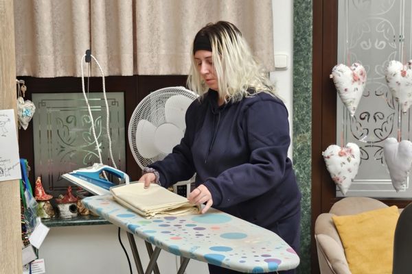 Mieszkanka prasuje materiał.