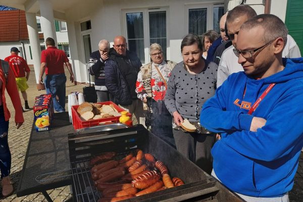 Mieszkańcy korzystają z grilla na tarasuie,tańczą,  grają w kręgle , częstują się kiełbaskami.