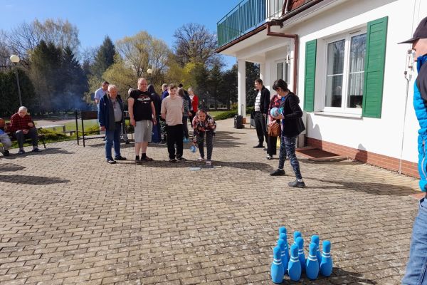 Mieszkańcy korzystają z grilla na tarasuie,tańczą,  grają w kręgle , częstują się kiełbaska